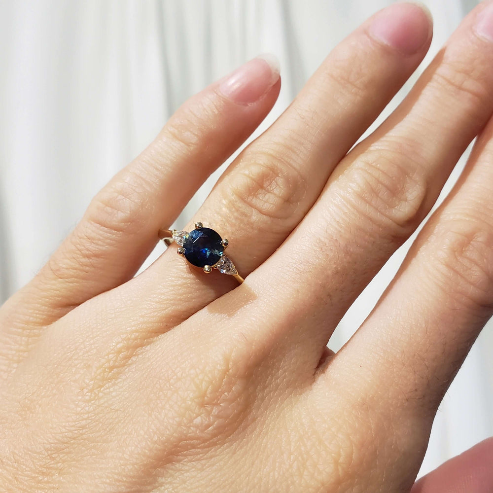 Australian sapphire and lab diamond engagement ring on hand in natural light
