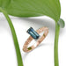 Australian sapphire engagement ring in rose gold with engraved band, shown with green leaf