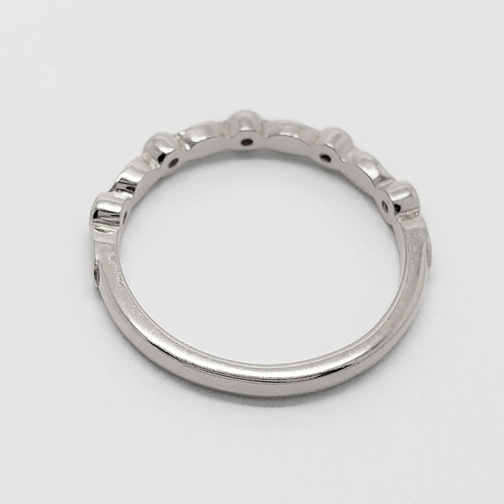 Back view of 14k white gold wedding ring with leaf and bezel set diamond details