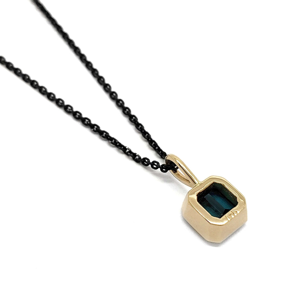 Back view of 14kt yellow gold bezel pendant with teal tourmaline on black chain