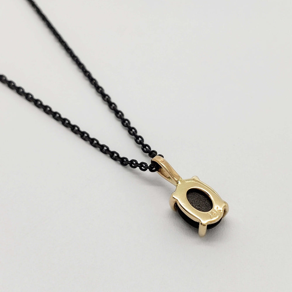 Back view of 14kt yellow gold star sapphire pendant on black chain