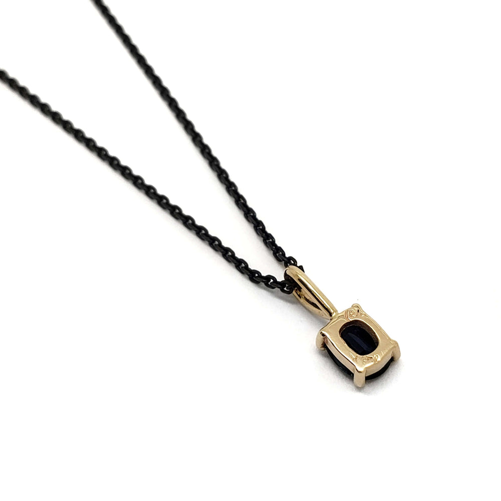 Back view of cushion blue sapphire pendant in 14kt yellow gold on a black chain