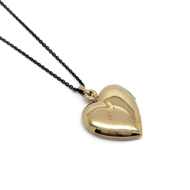 Back view of vintage 14kt yellow gold heart locket pendant on a black chain
