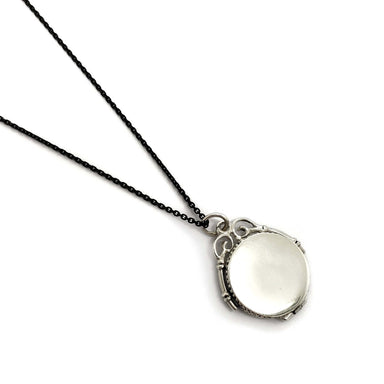 Back view of vintage sterling silver round locket on a black chain