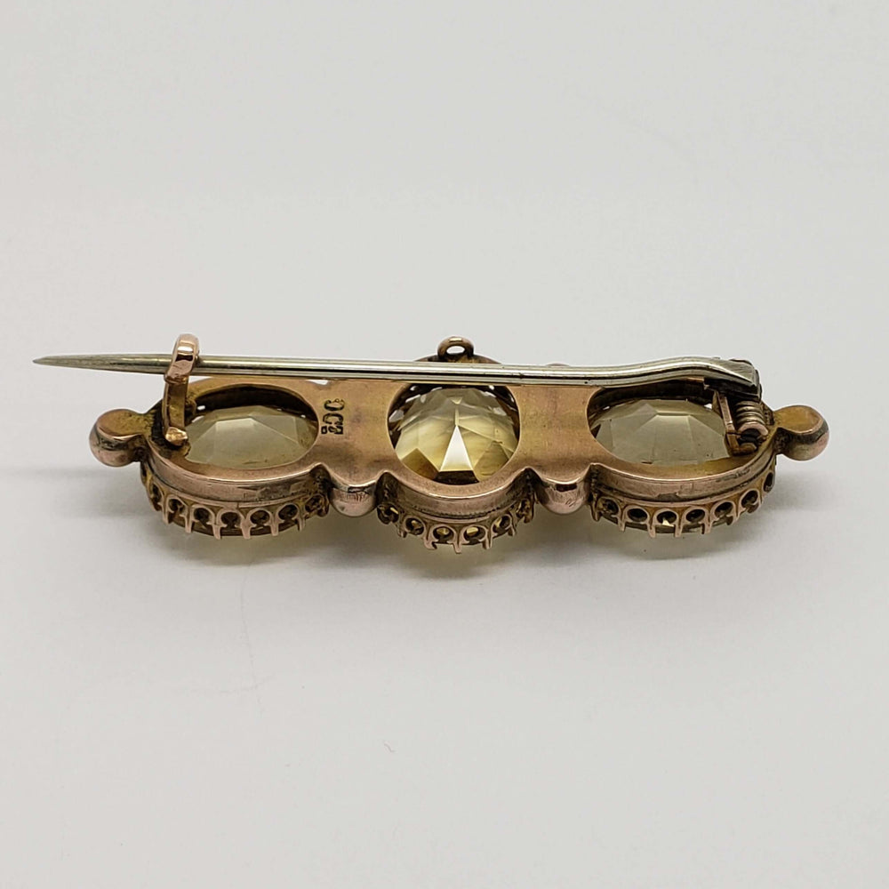 Back view of vintage yellow gold brooch with three faceted citrine stones