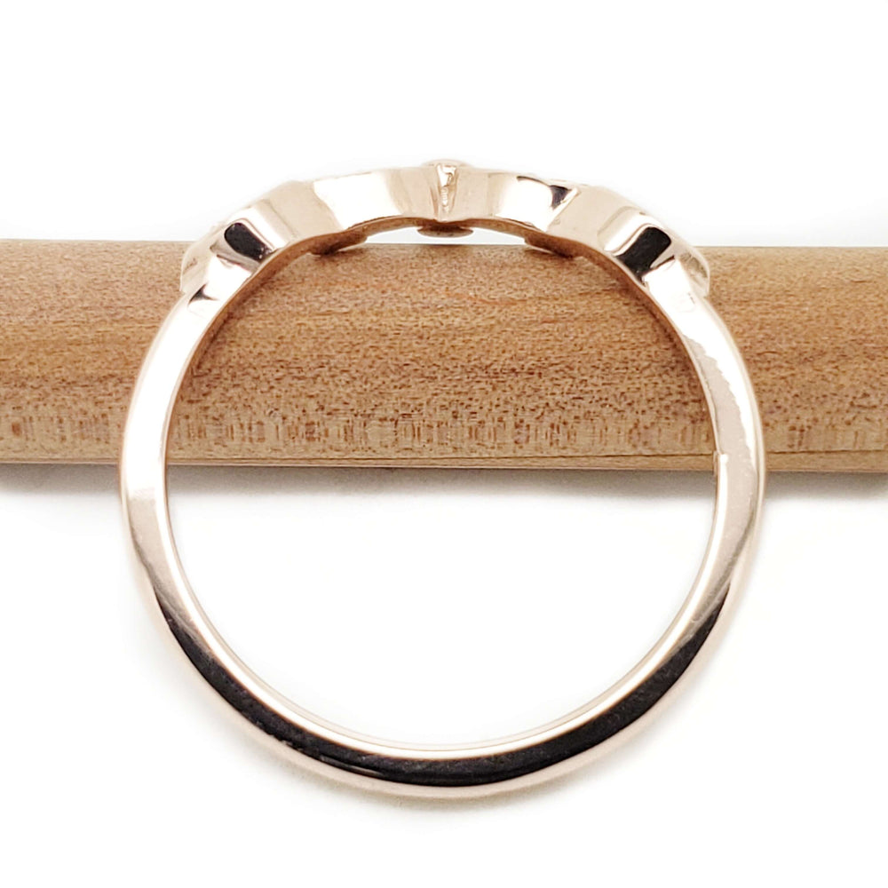 Back view of 14k rose gold wedding ring band on wood