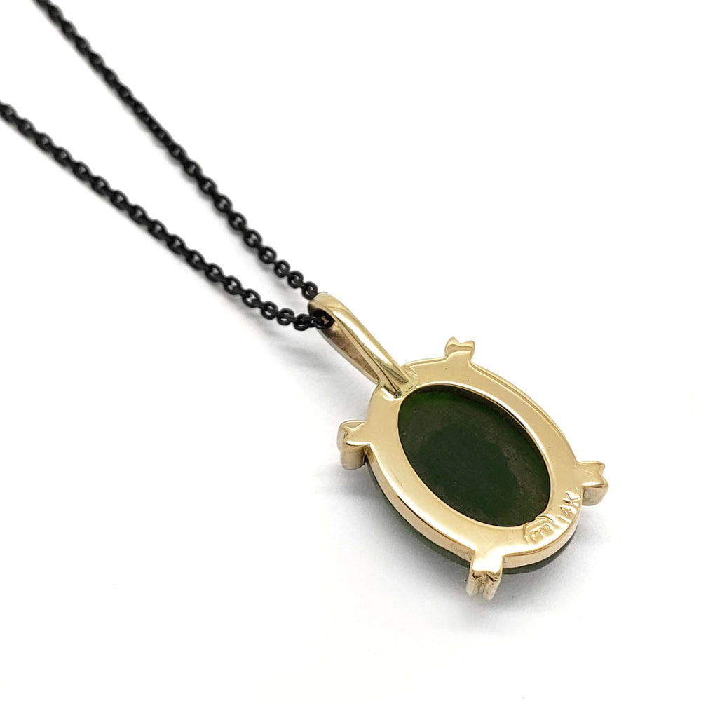 Back of 14kt yellow gold pendant showing oval jade setting and hallmark