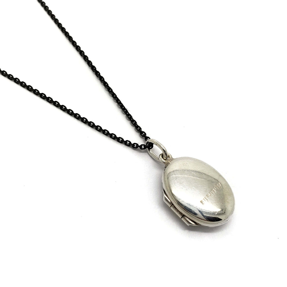 Vintage oval sterling silver locket, back view on a black chain