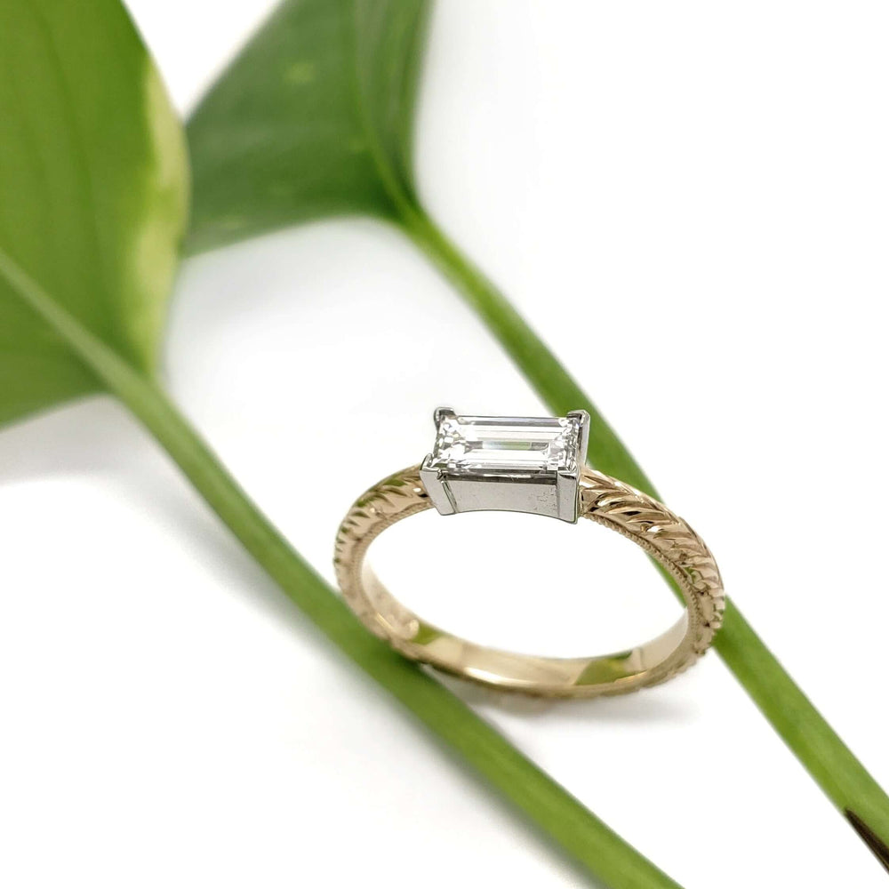 14kt yellow and white gold baguette diamond engagement ring displayed on green leaves