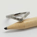 Berry Chevron II 14kt white gold wedding ring resting on a pencil, showing engraved details