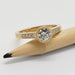 Bezel-set lab diamond engagement ring in yellow gold, displayed on a pencil