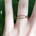 Bezel set diamond and engraved 14k rose gold ring worn on a hand