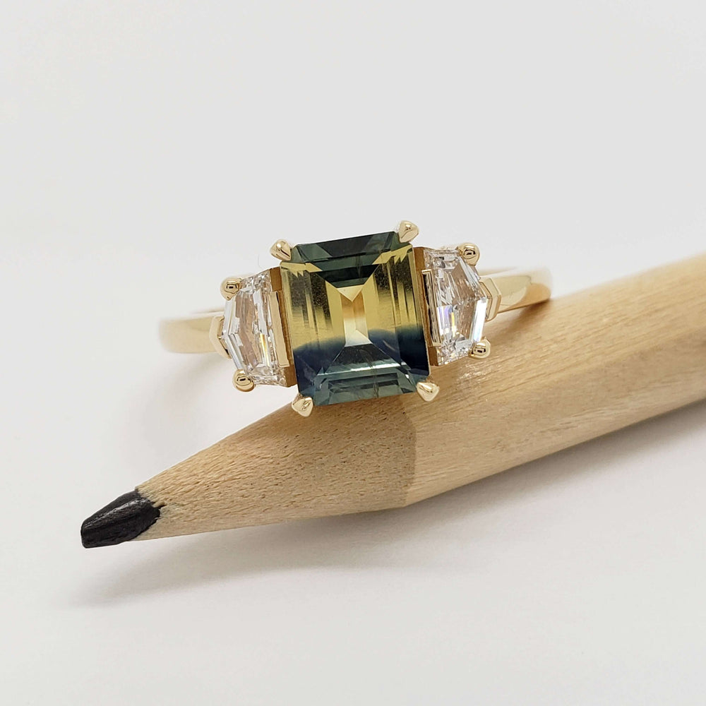 Bi-colour Australian sapphire and lab diamond yellow gold ring displayed on a pencil