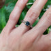 Blue Montana sapphire and white gold engagement ring worn on hand, engraved band visible