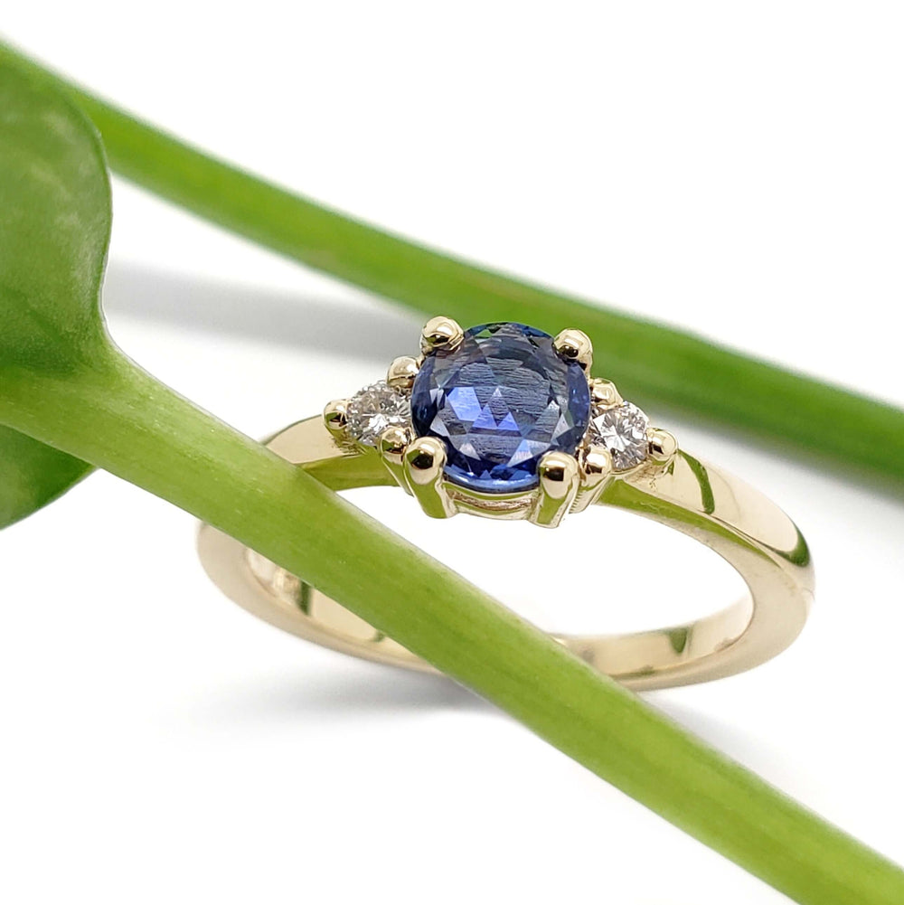 Blue sapphire and diamond engagement ring in yellow gold with plant accent