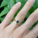 Blue sapphire and diamond engagement ring stacked with engraved yellow gold band on hand