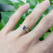 Blue sapphire and diamond yellow gold engagement ring shown on hand