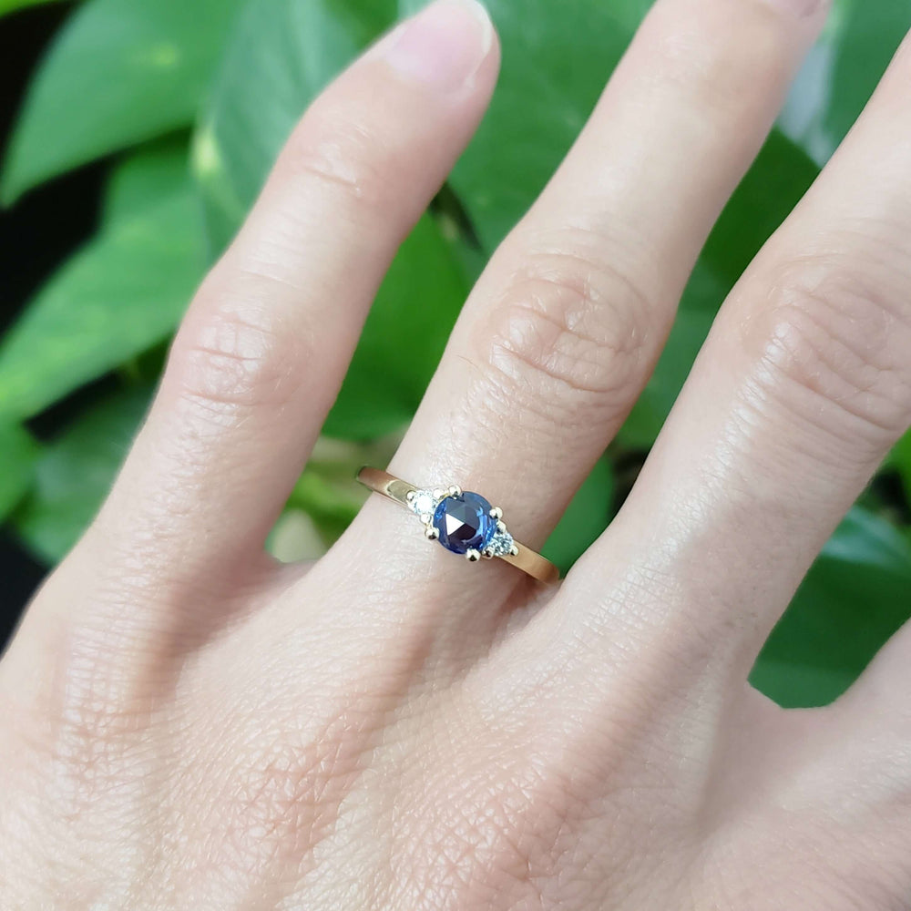 Blue sapphire and diamond ring in yellow gold shown on hand