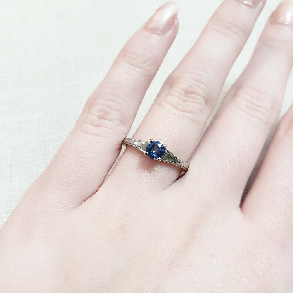 14kt white gold blue sapphire solitaire engagement ring shown on hand
