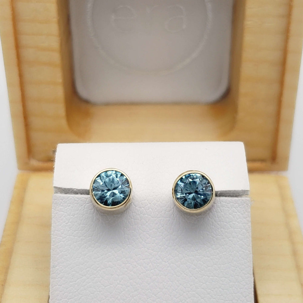 Blue zircon bezel earrings in 14kt yellow gold presented in an open cedar jewellery box