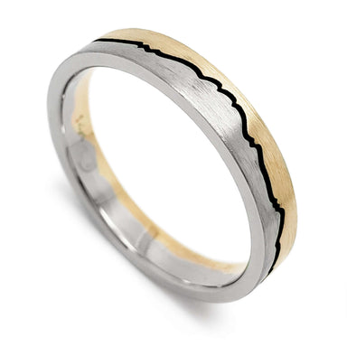 Brushed 14k white and yellow gold wedding ring with mountain range design and blackened groove