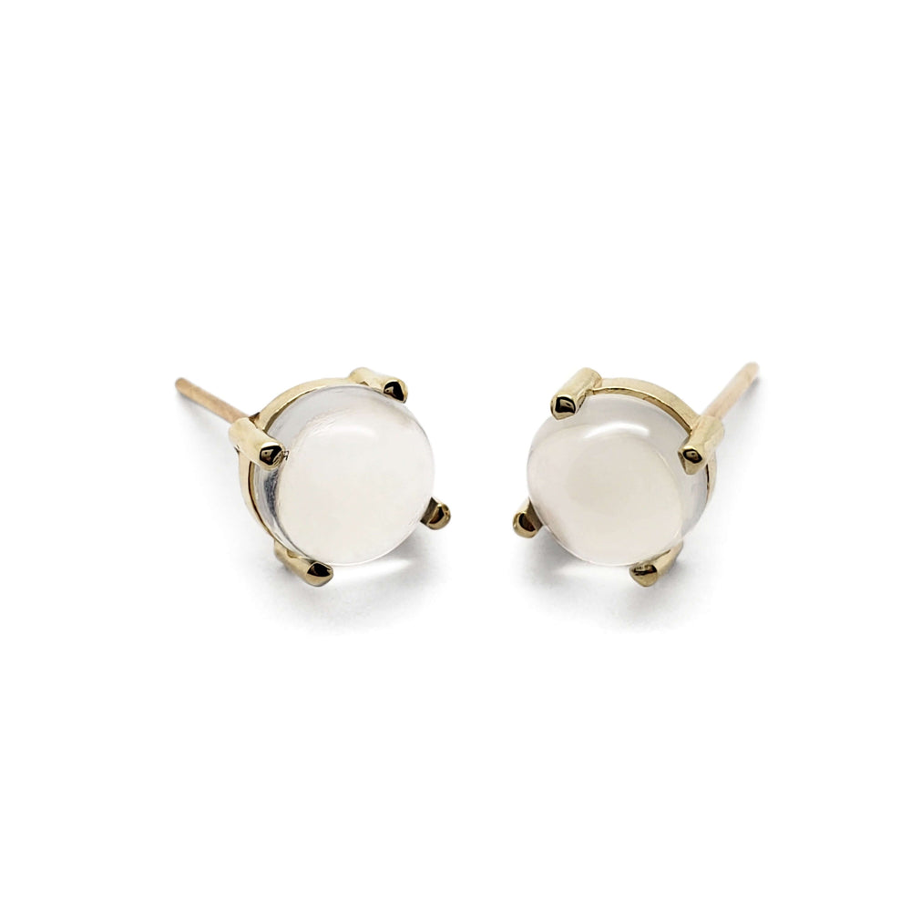 Pair of cabochon moonstone stud earrings in 14kt yellow gold on white background