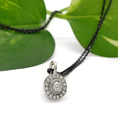 Canadian diamond halo pendant in 14kt white gold, styled with green leaves