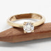Canadian diamond solitaire ring in 14kt yellow gold, front view on wood