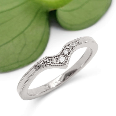 Chevron-shaped 14k white gold wedding band with Canadian diamonds, shown with green leaf