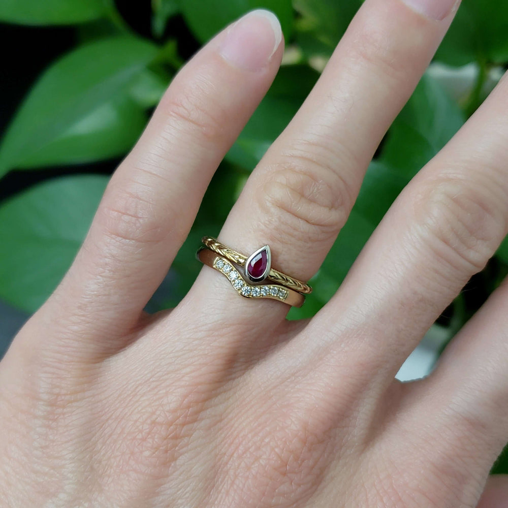 Chevron diamond band paired with a ruby ring on hand