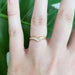 14k yellow gold chevron diamond wedding band shown on a hand