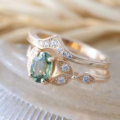 Stacked yellow gold chevron wedding band with diamonds paired with a green sapphire engagement ring