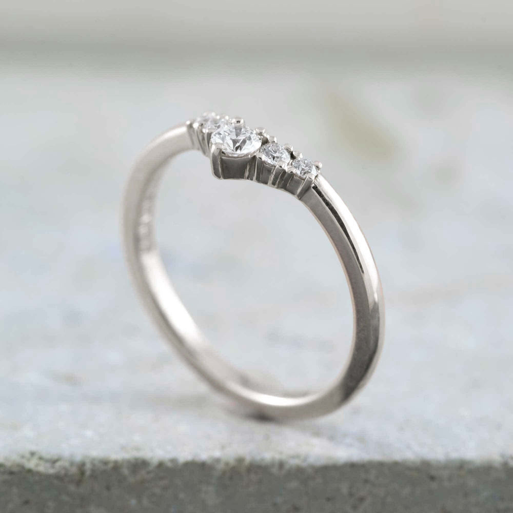 Chevron diamond wedding ring in 14kt white gold on stone background