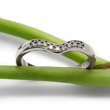 Chevron diamond wedding ring in 14kt white gold displayed on green stems