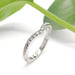 Chevron diamond wedding ring in 14kt white gold with engraved details, shown with green leaves