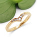 Chevron diamond wedding ring in 14k yellow gold with millgrain, shown near a green leaf