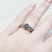 Chevron diamond wedding ring stacked with blue sapphire engagement ring on hand