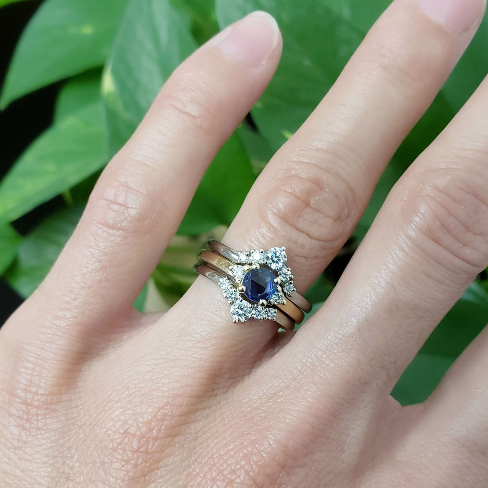 Chevron diamond wedding ring stacked with sapphire and diamond ring on hand