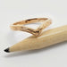 Chevron wedding ring in 14k yellow gold with scroll engraving, shown with pencil