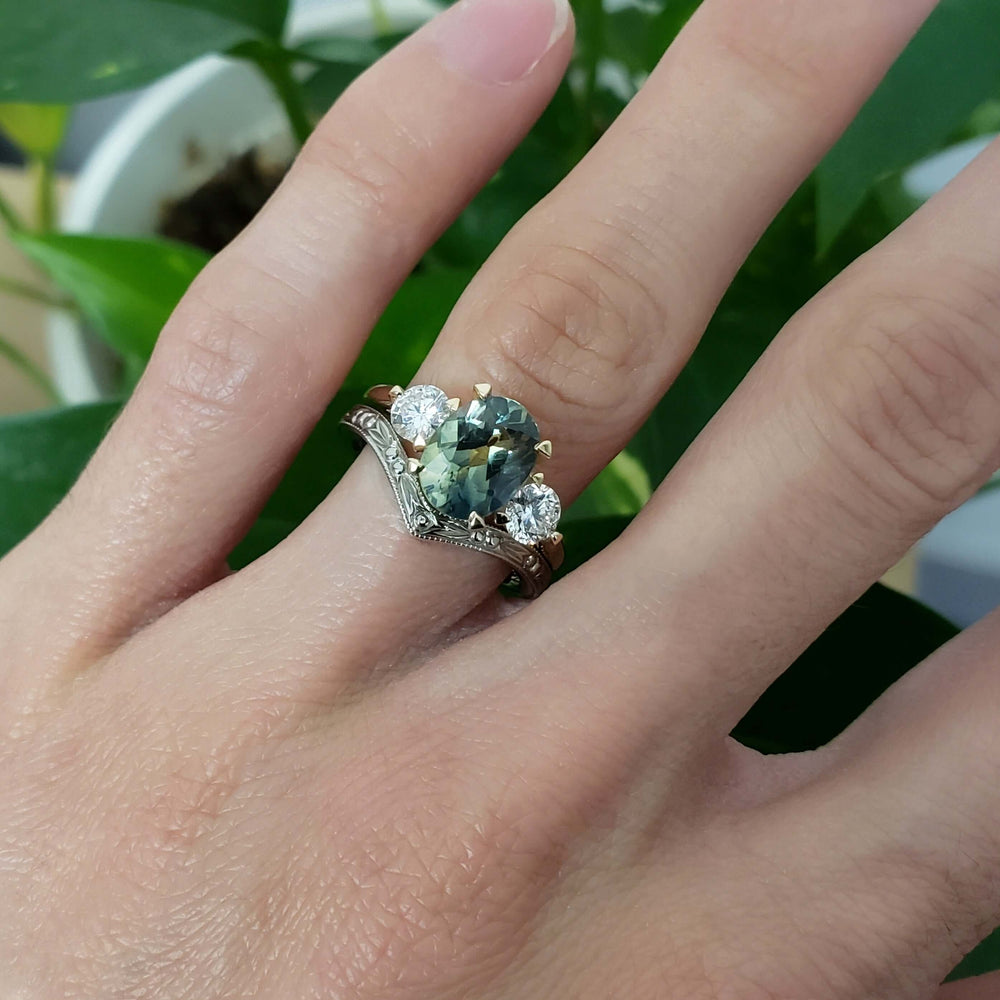Chevron wedding ring in 14kt white gold paired with a three-stone sapphire and diamond ring