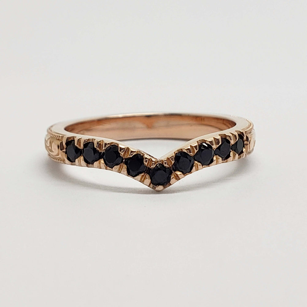 Front view of chevron wedding ring in rose gold with black spinels and engraved details