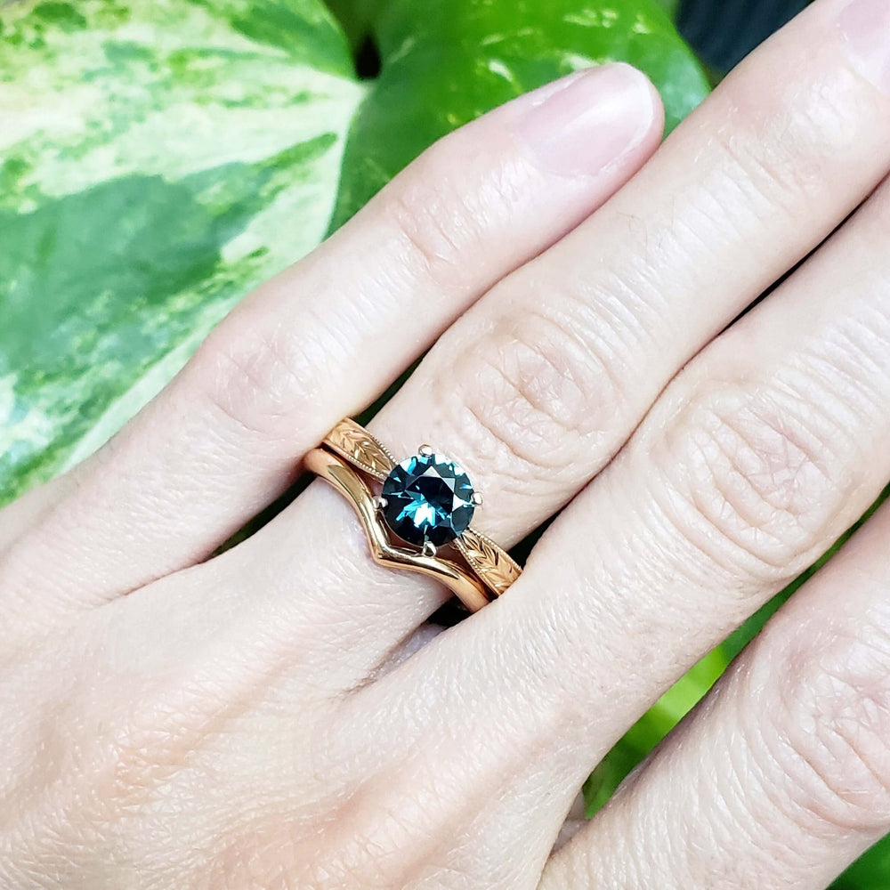 Chevron wedding ring stacked with an engraved band and blue solitaire ring