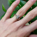 Yellow gold chevron wedding ring stacked with diamond engagement ring on hand