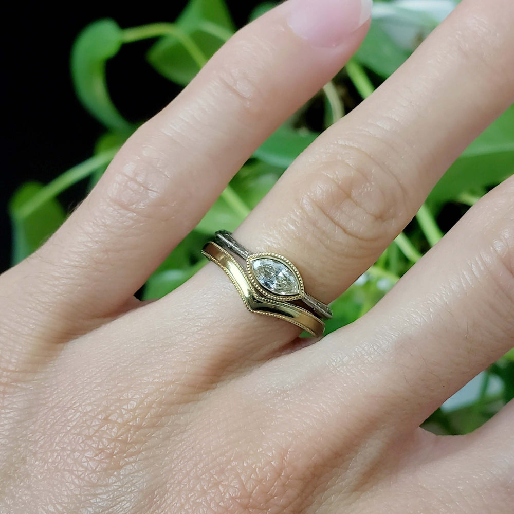 Chevron yellow gold wedding band paired with marquise diamond engagement ring