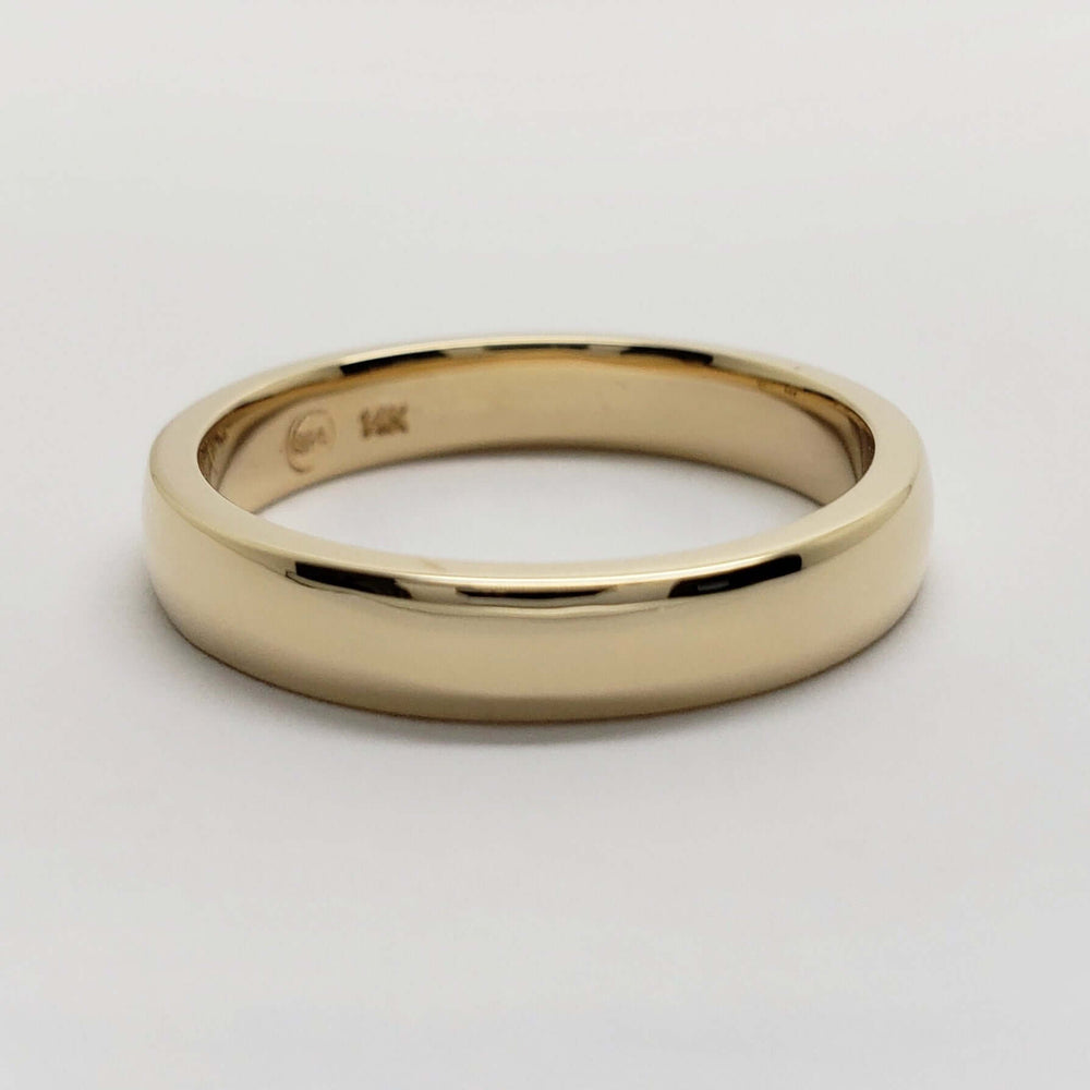 Classic 14kt yellow gold low dome wedding band on white background