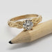 Close-up of 14K yellow gold engagement ring with round lab diamond beside a pencil