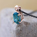 Close-up of an oval London topaz pendant in 14kt rose gold on a black chain