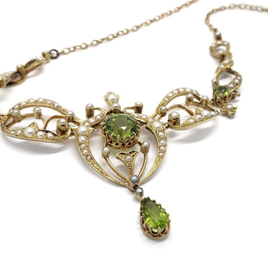 Close-up of antique peridot and seed pearl lavaliere in 14kt yellow gold