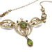 Close-up of antique peridot and seed pearl lavaliere in 14kt yellow gold