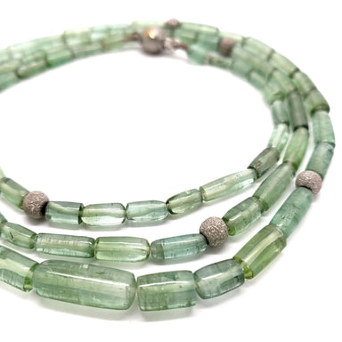 Close-up of elongated green tourmaline beads and textured white gold beads on necklace
